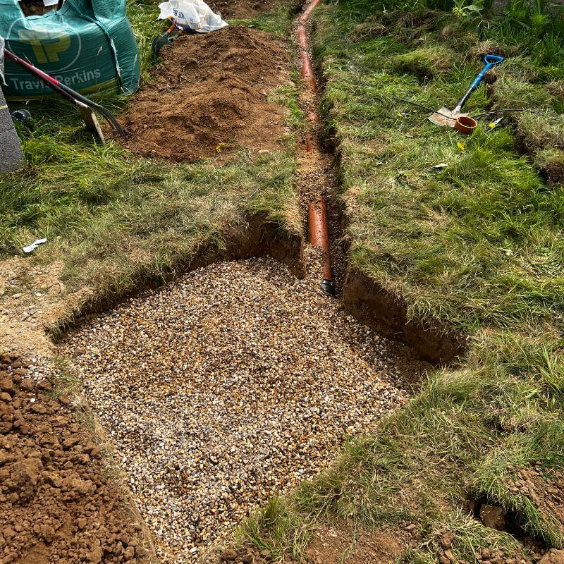 Soakaway with shingle on top and pipework